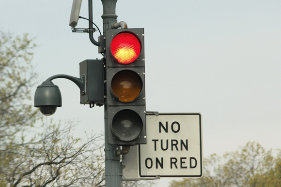 Semáforo rojo con cartel redundante